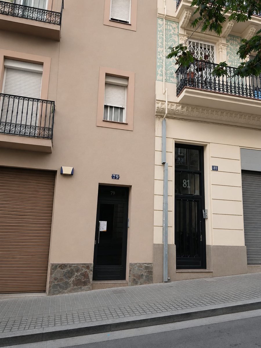 Portal del local de J&J Soluciones: puerta negra con el número 79 en Carrer del Poeta Cabanyes, Barcelona